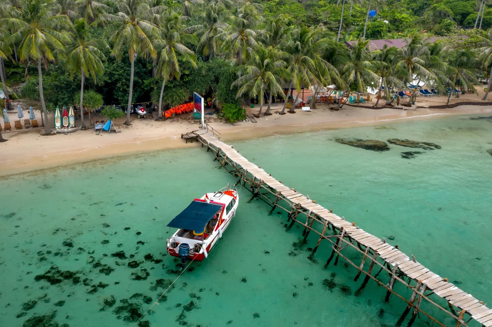Wooden Ko Kut pier amid palms and tropical shoreline